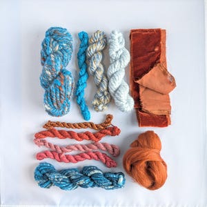 Teal and brown-rust hand-spun art yarn bundle for weaving, textile and fibre crafts.
