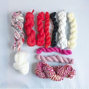 Red ,pink and white  yarn bundle for weaving textile and fibre crafts.