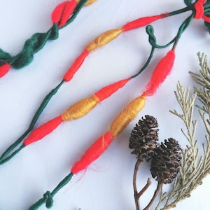 Grün, rot und goldene Bubble Art Garngirlande zum Weben, Basteln und als Weihnachtsdekoration.