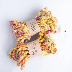 Yellow and pink bright handspun wool art yarns for weaving textile and fiber crafts.