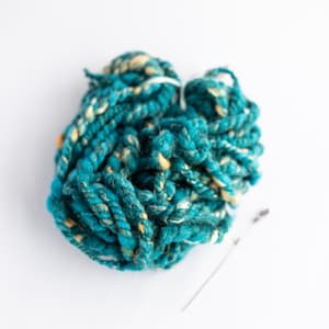 Teal and beige shiny hand-spun art yarn for weaving,textile and fiber crafts.