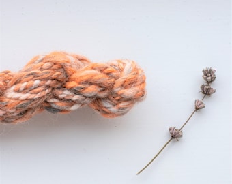 Peach, marble effect handspun drop spindle art yarn skein.