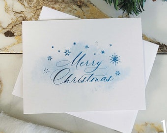 Tarjeta navideña con copo de nieve azul metalizado – Caligrafía elegante, nota en blanco, tarjeta festiva