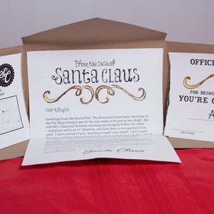 Set "Carta de Papá Noel" de 5 piezas. Diseño de desplazamiento dorado. Incluye Carta Personalizada, Certificado Niza, Aviso de Entrega y Carpeta Hecha a Mano.