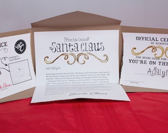 Set "Lettera da Babbo Natale" da 5 pezzi. Design a scorrimento dorato. Include lettera personalizzata, certificato di Nizza, avviso di consegna e cartella fatta a mano.