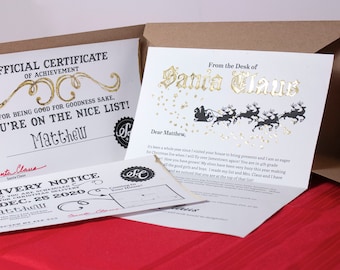 Set "Lettera da Babbo Natale" da 5 pezzi. Design con slitta dorata. Include lettera personalizzata, certificato di Nizza, avviso di consegna e cartella fatta a mano.