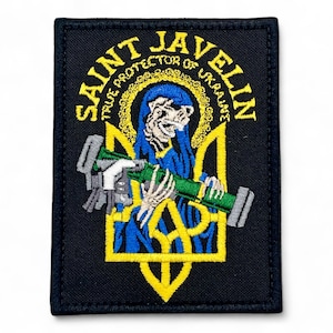 Puede incluir: Parche bordado con el texto "SAINT JAVELIN TRUE PROTECTOR OF UKRAINE" en amarillo. El parche presenta una figura de esqueleto azul sosteniendo un arma verde y gris, sobre un emblema amarillo y azul sobre fondo negro.
