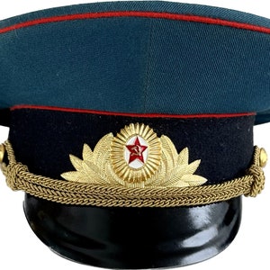 May include: A dark green military cap with a red band, a black brim, and a gold star and laurel wreath emblem.