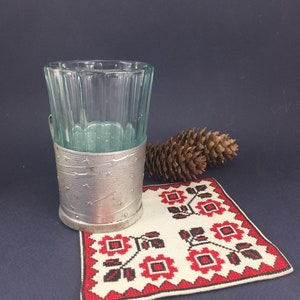 Peut inclure: Un verre &agrave; shot en verre transparent avec un support en m&eacute;tal argent&eacute;. Le support est d&eacute;cor&eacute; d'&eacute;toiles et d'un croissant de lune. Le verre est pos&eacute; sur un dessous de verre brod&eacute; blanc et rouge.