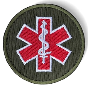 May include: Round embroidered patch featuring a red Star of Life emblem with a white staff and snake symbol at the center. The star is outlined in white, set against a dark green background with a matching border.