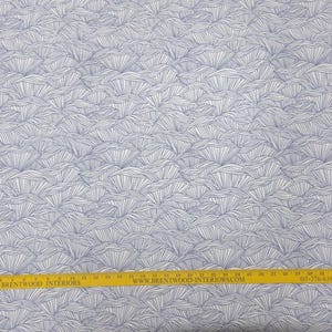 May include: White fabric with a repeating blue wave-like pattern. A yellow ruler with black text is at the bottom. The ruler measures in inches.