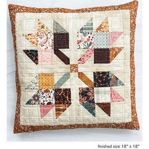 Puede incluir: Un cojín cuadrado de patchwork con un diseño de estrella. El cojín presenta un fondo crema con un patrón de estrella de patchwork en varias telas florales y geométricas. El tamaño final es de 45,7 cm x 45,7 cm. El borde es un estampado floral marrón.