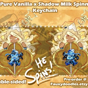 May include: Double-sided keychain featuring a cartoon character with a gold crown and flowing hair, and a blue character at the bottom. The keychain is 3 inches in size and has the text "HE SPINS!" and "Double-sided!"