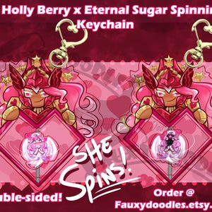 May include: Double-sided keychain featuring a pink and gold character holding a heart-shaped emblem. The emblem has a spinning design inside. The keychain is 3 inches (7.6 cm) in size and has a heart-shaped clasp.