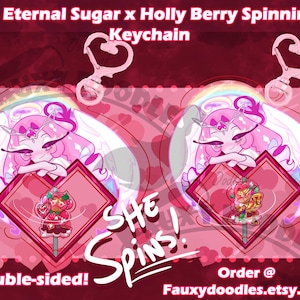 May include: A double-sided keychain featuring a pink cartoon character with angel wings and a heart-shaped pendant. The keychain is 3 inches in size and has the text "Eternal Sugar x Holly Berry Spinning Keychain". The text "She Spins!" is also visible.