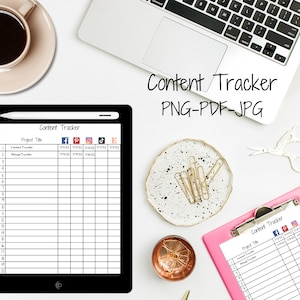 May include: A pink clipboard with a white content tracker sheet. The sheet has columns for project title, Facebook, Pinterest, Instagram, TikTok, and Email. The sheet is on a white surface with a laptop, a cup of coffee, and a pair of scissors.