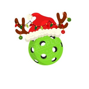 Op de afbeelding: Een groene pickleball met een rode en witte kerstmanmuts en rendiergewei. De muts heeft een kerstverlichting eromheen en er hangen rode en groene kerstballen aan het gewei.