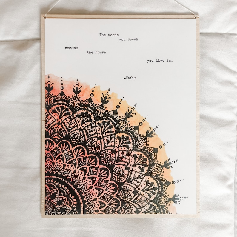 May include: A watercolor print with a black and white mandala design and a quote by Hafiz: "The words you speak become the house you live in."