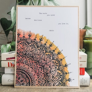 May include: A watercolor print with a black and white mandala design. The print features a quote by Hafiz: "The words you speak become the house you live in."