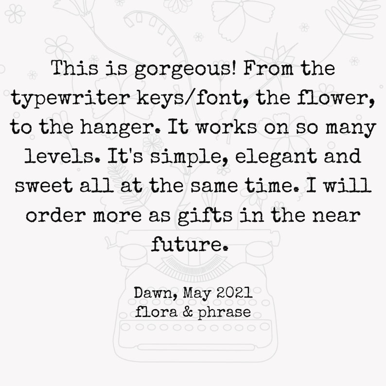 May include: Black and white image of a typewriter with a handwritten note that reads: "This is gorgeous! From the typewriter keys/font, the flower, to the hanger. It works on so many levels. It's simple, elegant and sweet all at the same time. I will order more as gifts in the near future. Dawn, May 2021 flora & phrase"