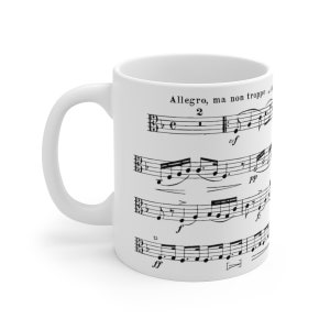 May include: White ceramic mug with a black and white musical score printed on it. The score reads "Allegro, ma non troppo" and includes musical notes and symbols.