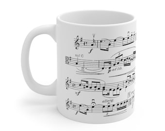May include: White ceramic mug with a black and white musical score printed on the side. The score includes musical notes, clefs, and markings such as "sul C", "p ad lib.", "mf", and "allarg."