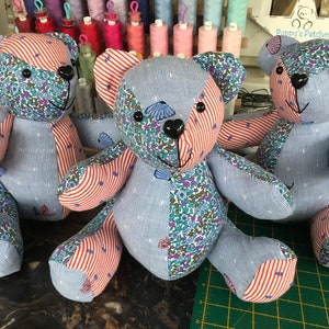 May include: Three patchwork teddy bears with a variety of fabrics. The bears have blue and white striped bodies, floral patterned heads, and red and white striped arms and legs. Each bear has a black nose and button eyes.