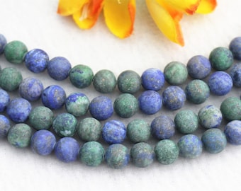 May include: A strand of blue and green gemstone beads. The beads are round and have a speckled appearance.