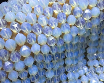 May include: A strand of light blue, faceted, opal beads. The beads are all the same size and shape, and they are strung together on a clear thread.
