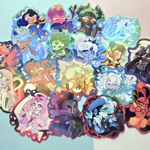 May include: A collection of holographic stickers featuring various stylized cartoon characters with diverse hair colors, outfits, and expressions. The stickers display vibrant hues including blue, pink, green, and purple, with a shimmering finish.
