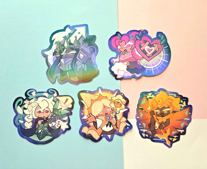 May include: Five holographic stickers featuring stylized cartoon characters. One shows a dark knight with a sword, another a pink character with a heart shield, a white-haired figure with lilies, a sun-themed character, and a fiery orange figure.