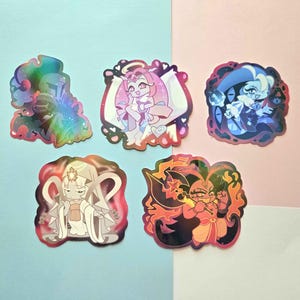May include: Five die-cut stickers featuring stylized anime-inspired characters. The top left is a holographic knight, the top center is a pink-haired figure with wings, the top right is a blue-toned character, the bottom left is a white-robed figure, and the bottom right is a fiery character.