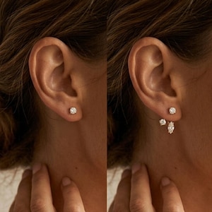 Peut inclure: Un ensemble de boucles d'oreilles dorées comprenant un clou à pierre ronde transparente sur l'image de gauche, et un bijou d'oreille sur l'image de droite, composé d'un clou et d'une pièce pendante avec une pierre ronde et une taille marquise.