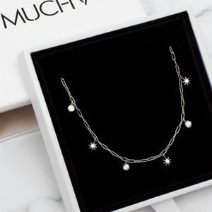 Sterling silver paperclip chain necklace for layering with six tiny moon and star charms.