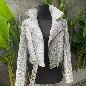 May include: A grey snakeskin biker jacket with a zip fastening and a belt at the waist.