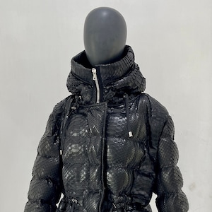 Peut inclure: Une veste matelassée noire à motif peau de serpent et taille cintrée.