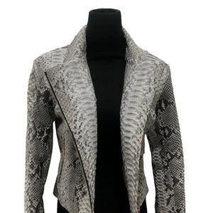 May include: A grey snakeskin leather jacket with a zip closure. The jacket has a collar that can be worn up or down.