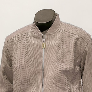 May include: A gray snakeskin bomber jacket with a zipper closure. The jacket has a ribbed collar, cuffs, and waistband.