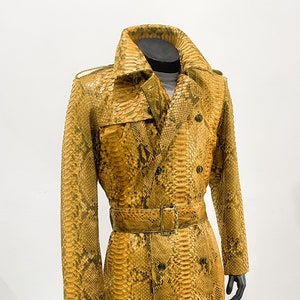 May include: A long yellow snakeskin trench coat with a double breasted closure and a belt.