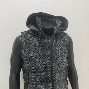 May include: A sleeveless hooded vest with a black and green snake skin pattern. The vest has a zipper closure and a stand-up collar.