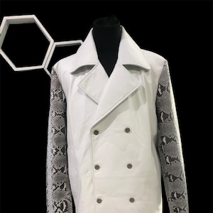 May include: A white leather coat with a double-breasted closure and long sleeves. The sleeves are made of a black and white snake skin pattern.