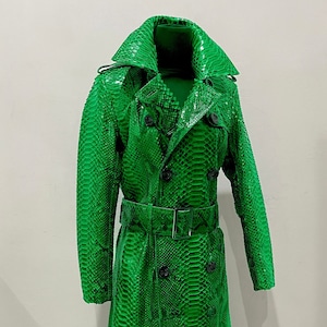 May include: A long green snakeskin trench coat with a double breasted closure, a belt, and a collar.