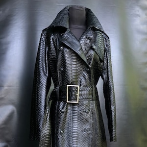 May include: A black snakeskin trench coat with a double-breasted closure, a belt, and a long, flowing silhouette.