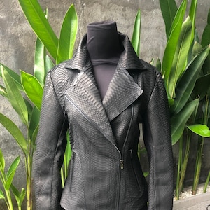 May include: A black leather jacket with a snakeskin pattern. The jacket has a zip fastening and a collar.