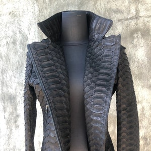May include: A black leather jacket with a zip fastening and a stand-up collar. The jacket is made of snakeskin.