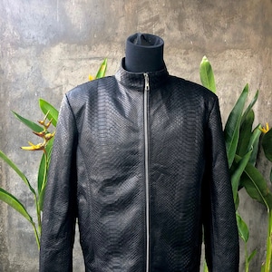 May include: A black leather jacket with a snakeskin pattern. The jacket has a zip fastening and a stand-up collar.