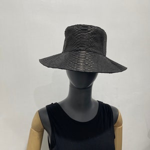 May include: A black snakeskin bucket hat with a wide brim.