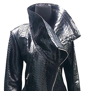 May include: A black leather jacket with a snakeskin pattern and a large, asymmetrical collar. The jacket has a zipper closure and two pockets.