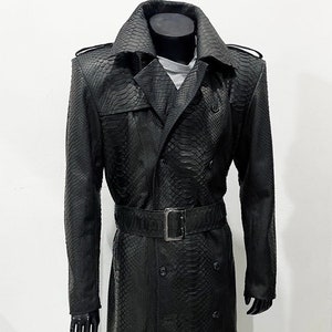 May include: A long black snakeskin trench coat with a double breasted closure, a belt, and a classic collar.