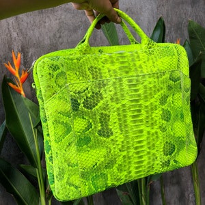 May include: A bright neon green snakeskin laptop bag with a zip closure and two handles.